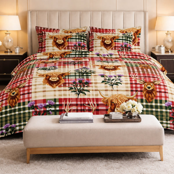 A made bed in a styled bedroom setting featuring a plaid and animal print bedding set with Highland cows, thistles, and stags. The bedding has a patchwork design with red, green, beige, and brown tones.