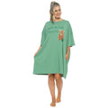 A woman modeling a sage green tunic-style nightshirt with 'NOT IN THE MOOD' and a brown bear graphic on the front, set against a plain white background.